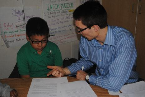 A teacher working one-on-one with a student on reading materials