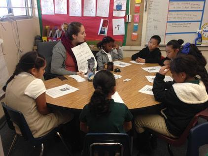 A teacher leading a small-group literacy discussion at a round table