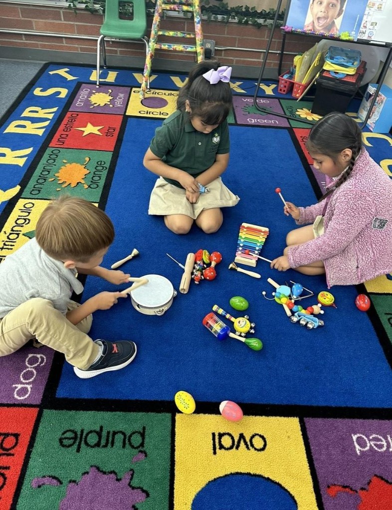 Young students playing with musical instruments on a classroom rug
