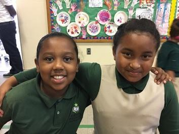 Two students smiling together in a classroom