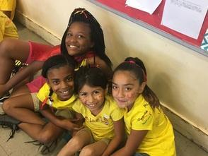 Students sitting together smiling in a school hallway