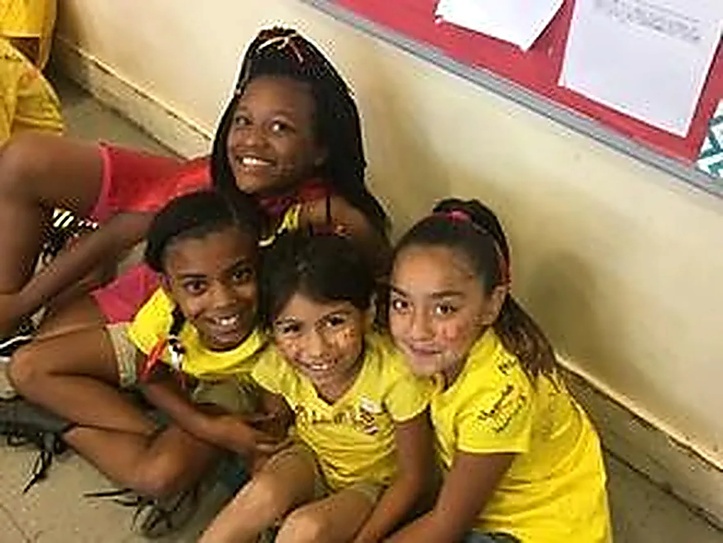 Students sitting together smiling in a school hallway