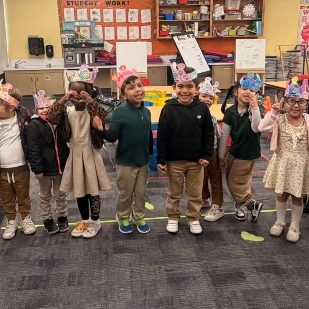 Students wearing celebration crowns together in a classroom